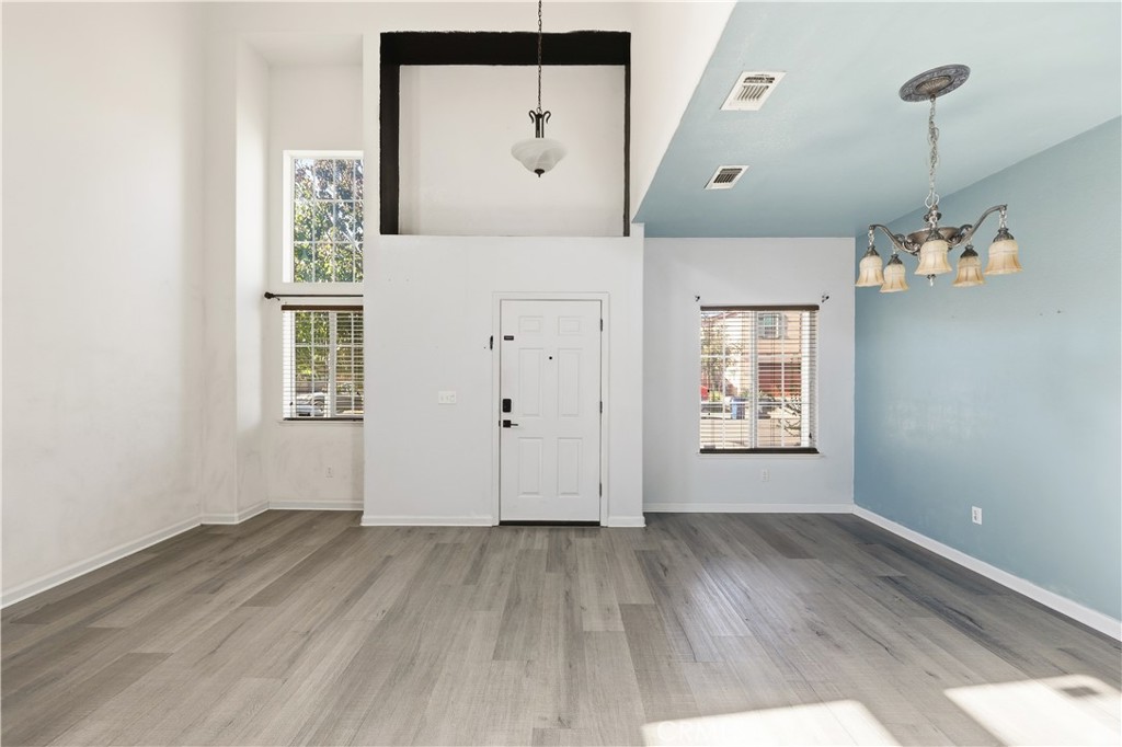 84 Jack Court Merced, CA 95341 - Photo 3 of 34 an empty room with wooden floor and windows
