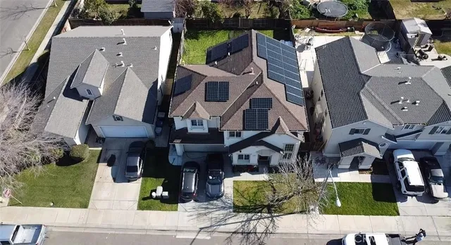 an aerial view of residential houses with outdoor space and parking