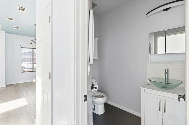 a bathroom with a toilet a sink and mirror