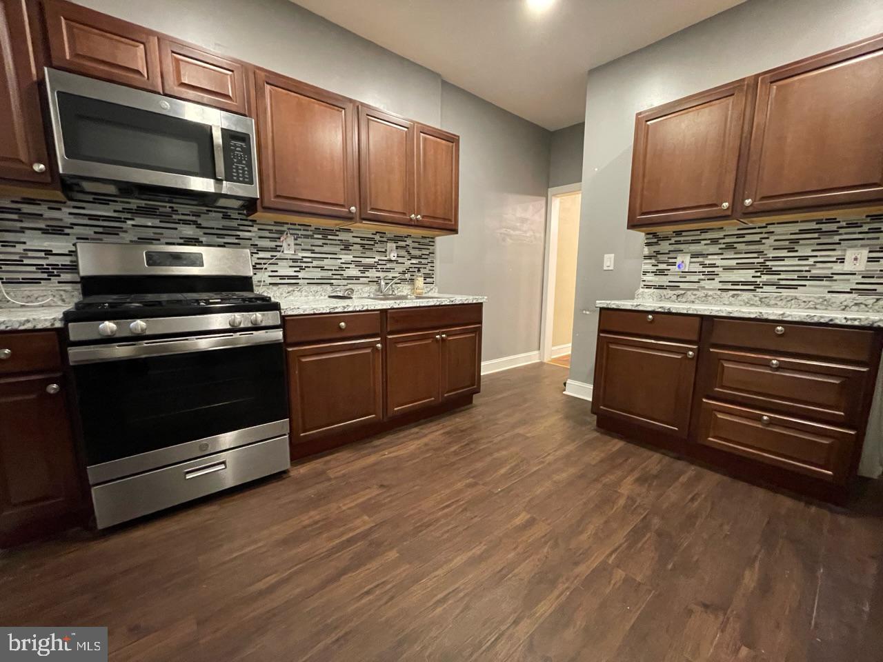 1115 West Wyoming Avenue Philadelphia, PA 19140 - Photo 12 of 33 a kitchen with stainless steel appliances granite countertop a stove microwave and cabinets