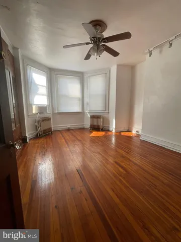 a view of wooden floor and a chandelier fan