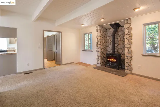 a kitchen with kitchen island granite countertop a stove and a wooden floors