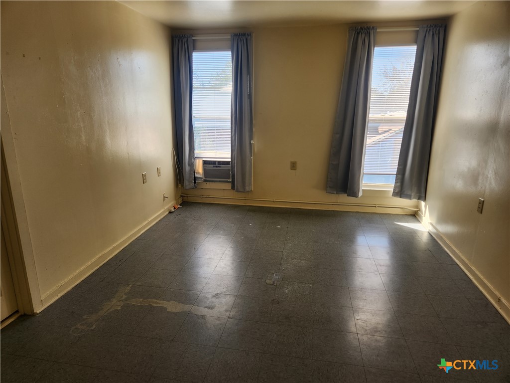 1205 South 17th Street Temple, TX 76504 - Photo 6 of 7 an empty room with wooden floor and windows