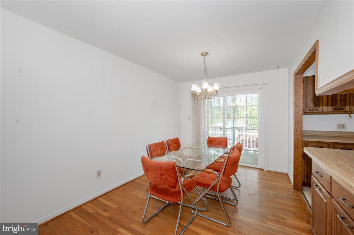 1300 Holliben Road Severna Park, MD 21146 - Photo 11 of 69 a dining room with furniture a chandelier and wooden floor