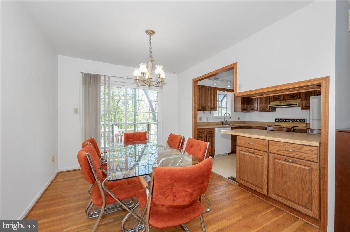 1300 Holliben Road Severna Park, MD 21146 - Photo 12 of 69 a dining room with furniture a chandelier and wooden floor