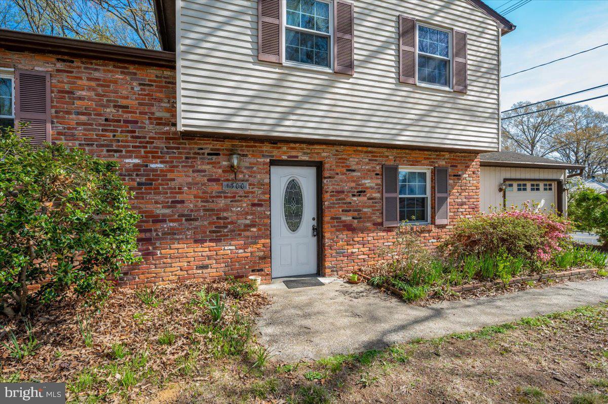 1300 Holliben Road Severna Park, MD 21146 - Photo 3 of 69 a view of a brick house with large windows and plants