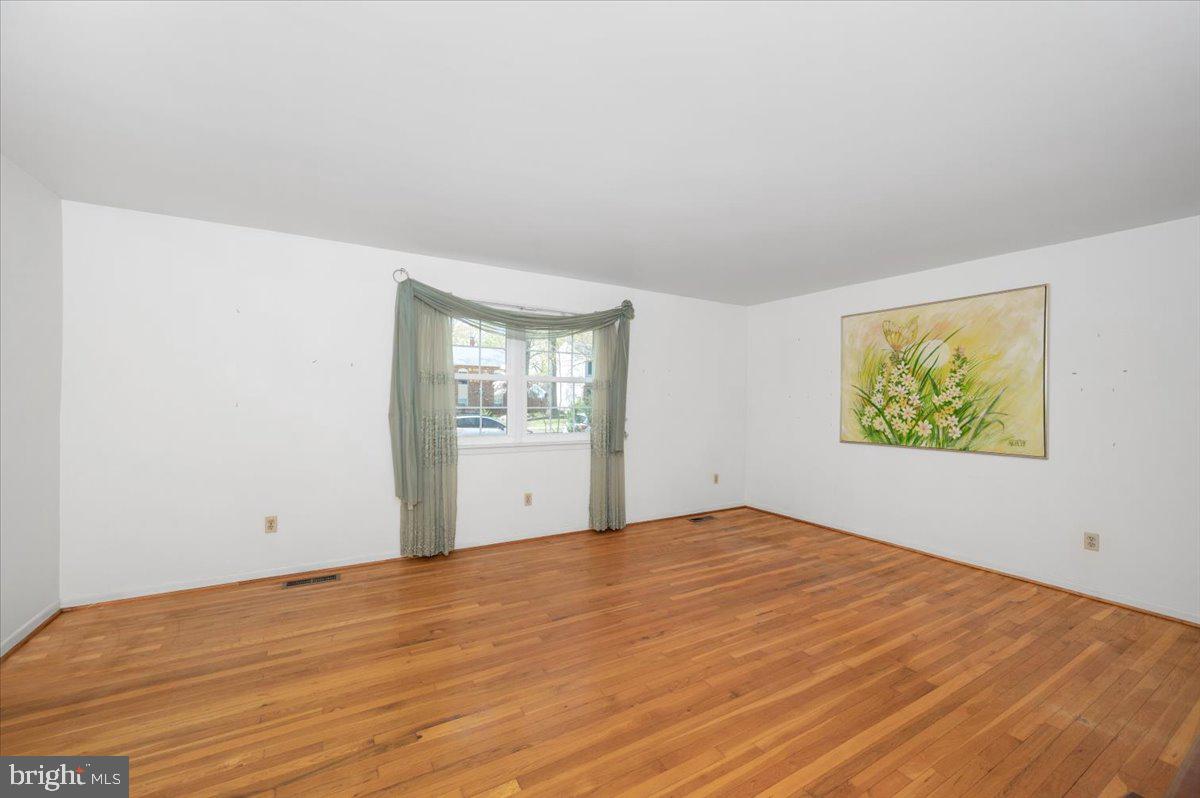 1300 Holliben Road Severna Park, MD 21146 - Photo 7 of 69 a view of an empty room with wooden floor and a window
