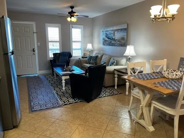 a living room with furniture a chandelier and a window
