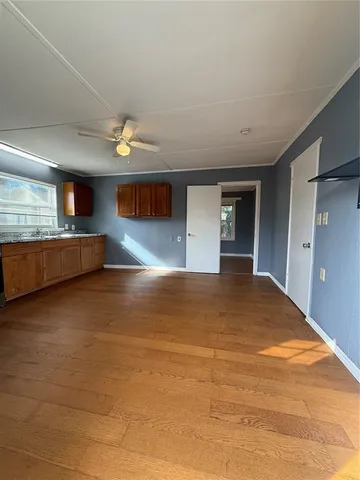 a view of empty room with kitchen and window