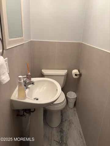 a bathroom with a sink toilet and mirror
