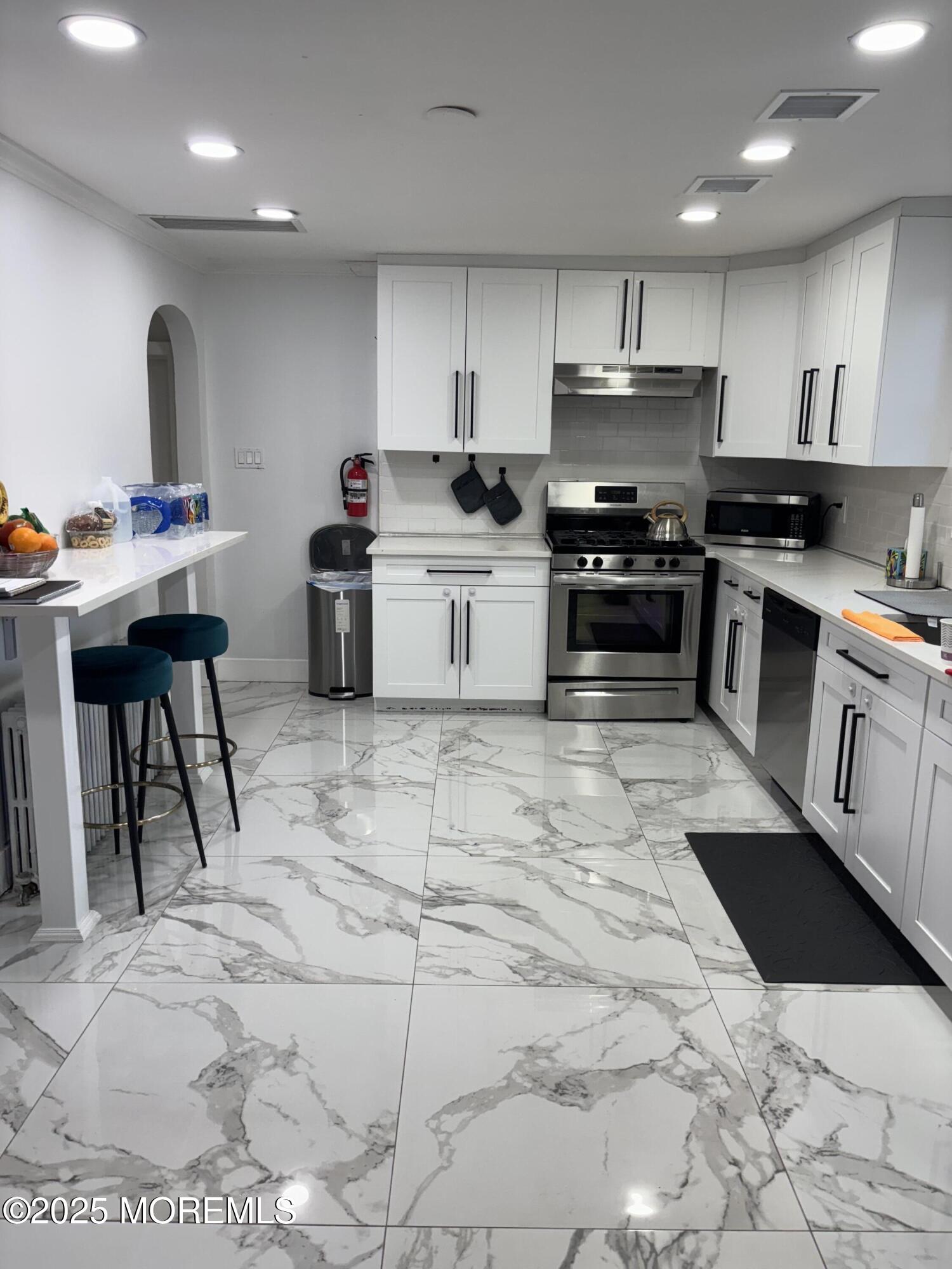 295 Roosevelt Avenue Oakhurst, NJ 07755 - Photo 4 of 16 a kitchen with granite countertop a stove a sink and a refrigerator