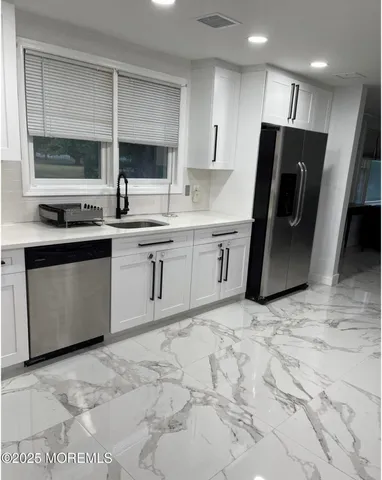 a kitchen with stainless steel appliances granite countertop a sink stove and refrigerator