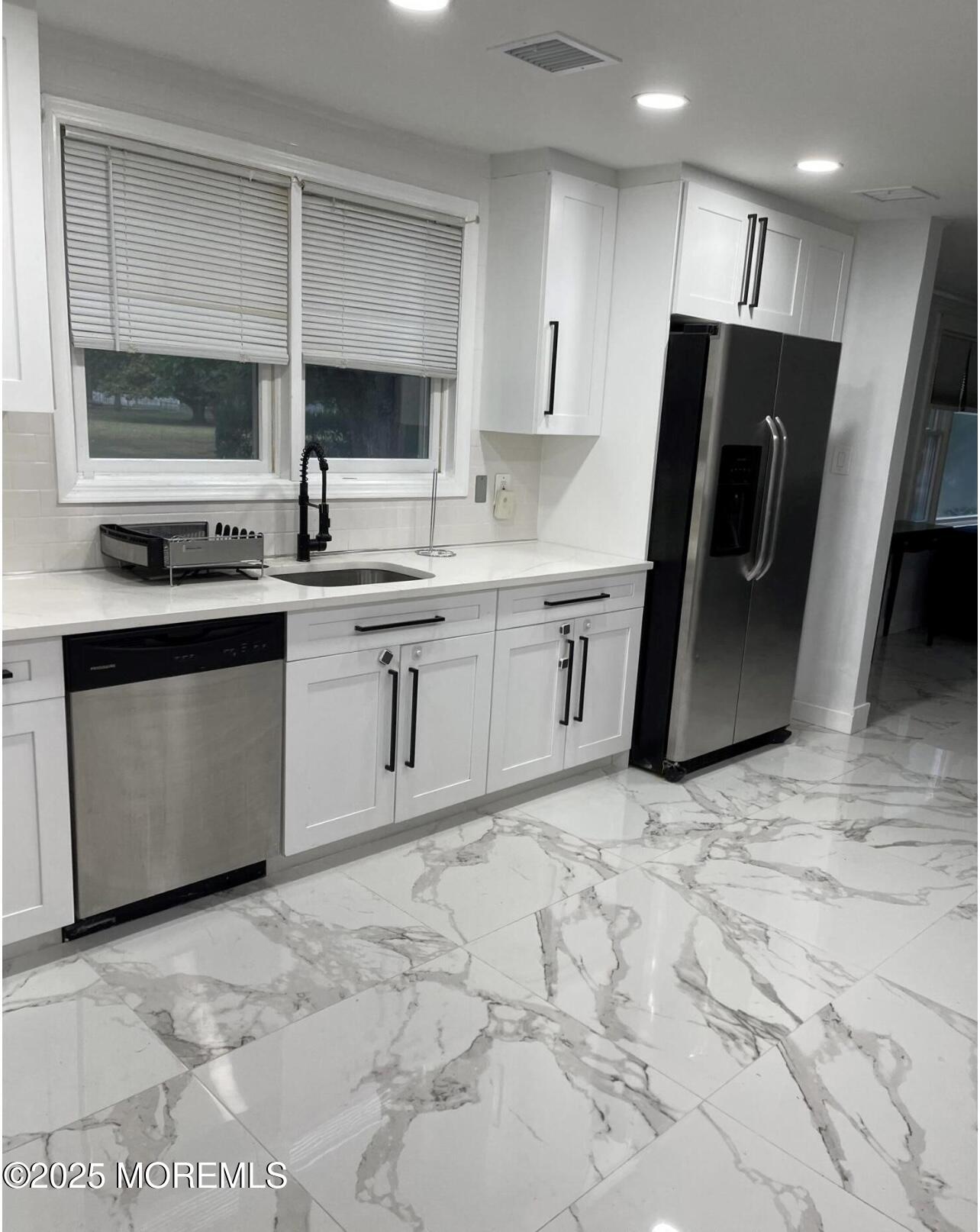 295 Roosevelt Avenue Oakhurst, NJ 07755 - Photo 5 of 16 a kitchen with stainless steel appliances granite countertop a sink stove and refrigerator