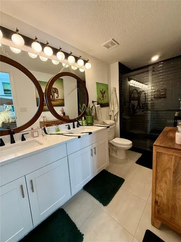 a bathroom with a double vanity sink mirror and toilet