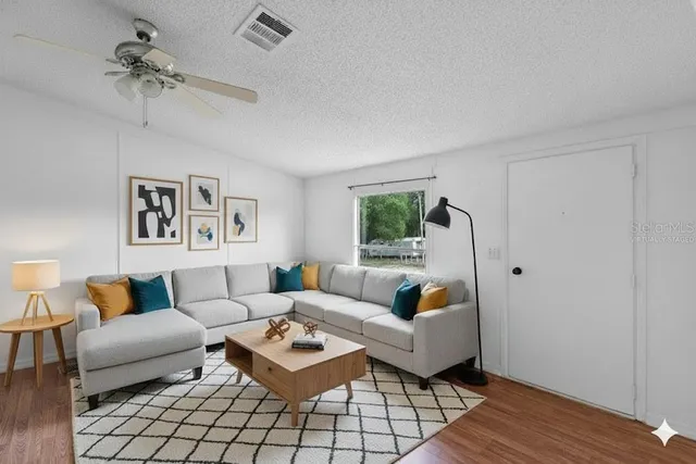 a living room with furniture and a wooden floor