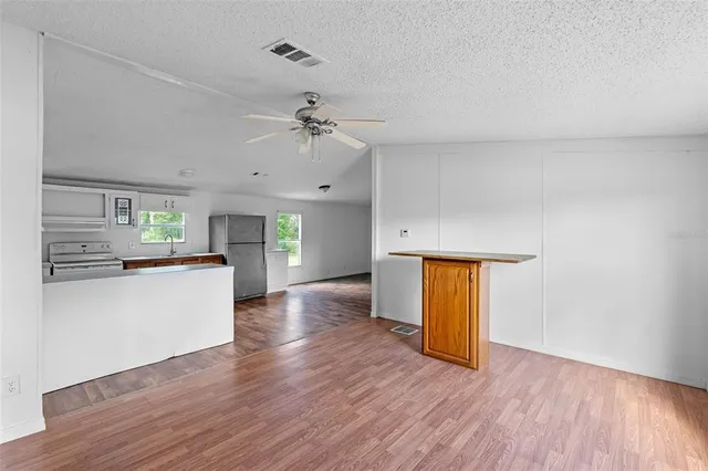 a view of a kitchen with wooden floor and a kitchen space