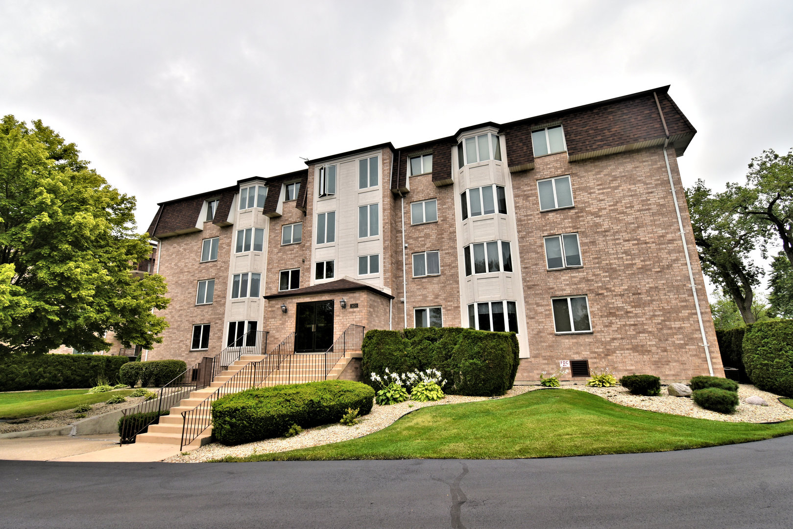 3620 186th Street, Unit 101 Lansing, IL 60438 - Photo 1 of 26 a front view of a building with garden