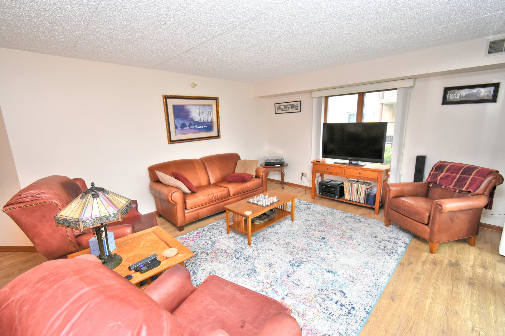3620 186th Street, Unit 101 Lansing, IL 60438 - Photo 5 of 26 a living room with furniture workspace and a flat screen tv