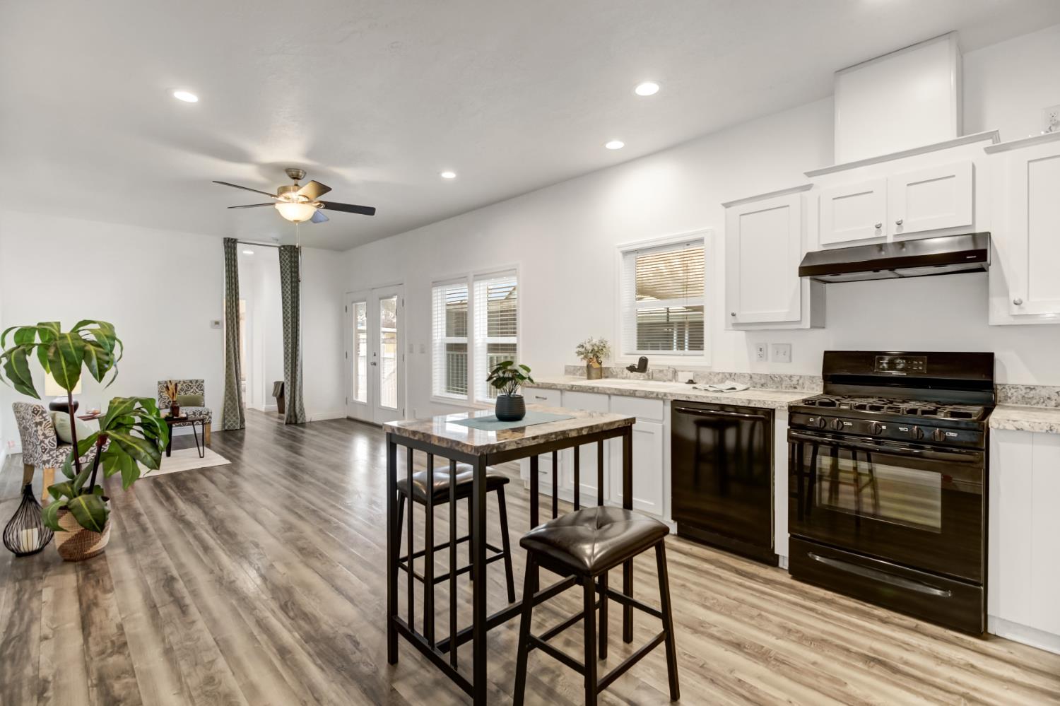 9060 Auburn Folsom Road, Unit 7 Granite Bay, CA 95746 - Photo 1 of 22 a kitchen with stainless steel appliances a stove a sink dishwasher a dining table and chairs with wooden floor