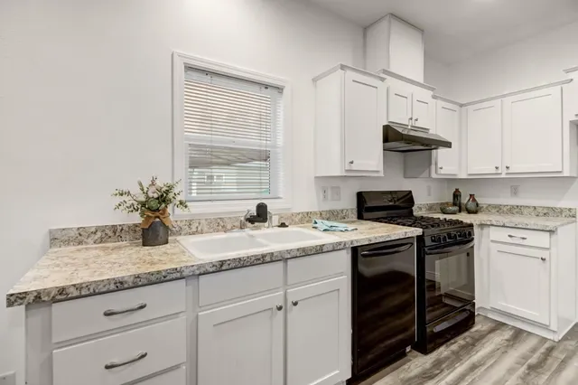 a kitchen with a sink stove and cabinets