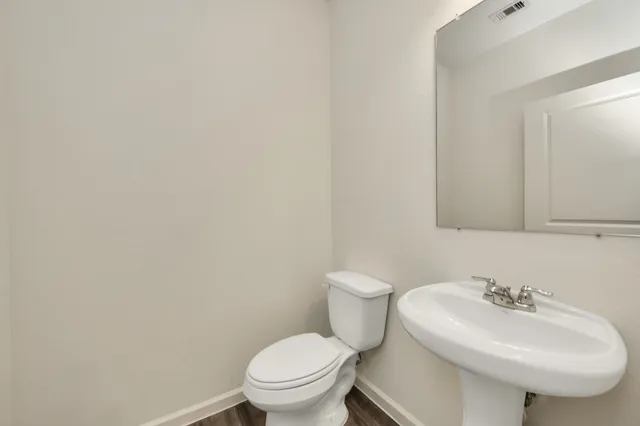 a bathroom with a sink toilet and a mirror