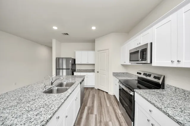 a kitchen with stainless steel appliances granite countertop a sink stove and refrigerator