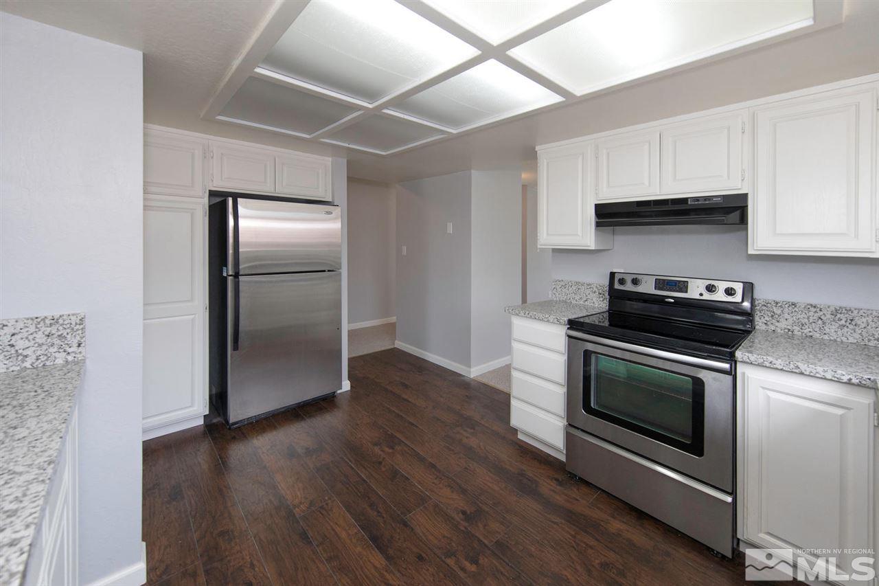1394 Frontier Street Reno, NV 89503 - Photo 6 of 22 a kitchen with granite countertop a refrigerator and a stove top oven
