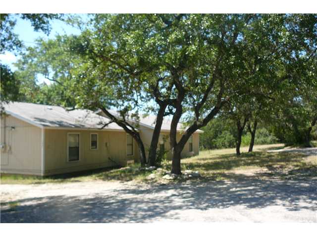 a view of a yard with plants and trees