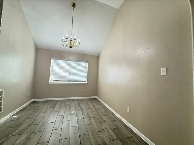 a view of a room with a window and wooden floor