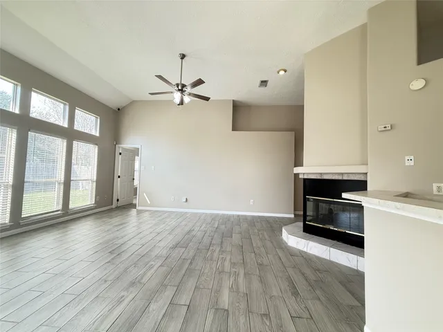 a view of an empty room with a fireplace and a window