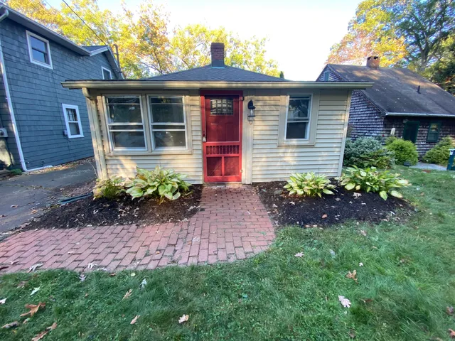 a front view of a house with a yard and outdoor seating