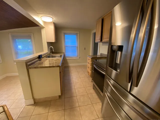 a kitchen with a sink a stove top oven and cabinets