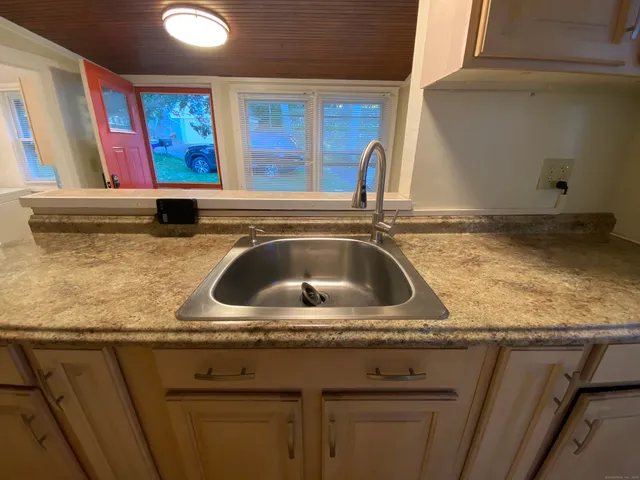 a kitchen with granite countertop sink and window