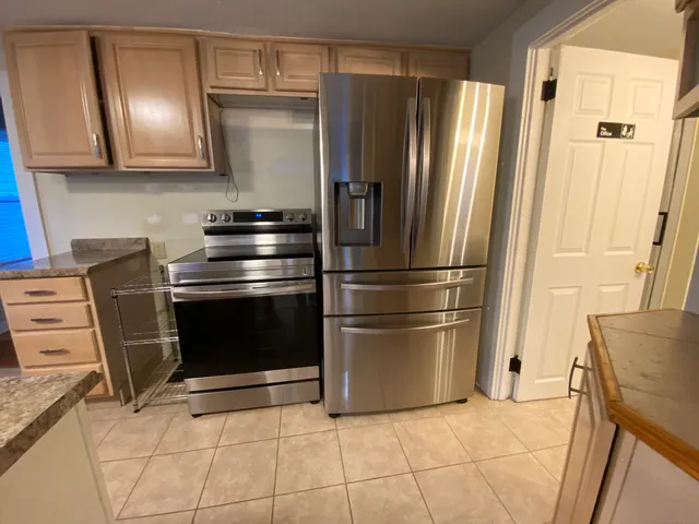 a kitchen with granite countertop a refrigerator and a stove
