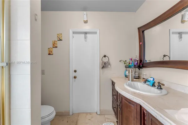 a bathroom with a granite countertop sink and a mirror