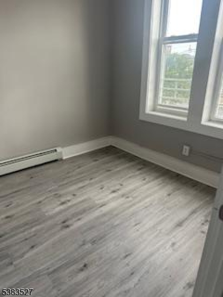 104 President Street, Unit 8 Passaic, NJ 07055 - Photo 6 of 8 an empty room with wooden floor and windows