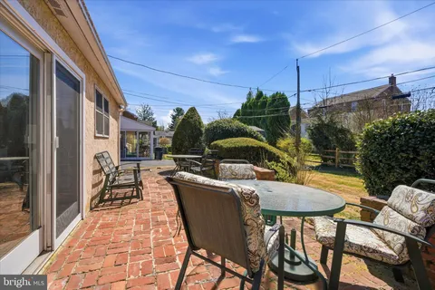 a view of a patio with table and chairs potted plants with wooden floor and fence
