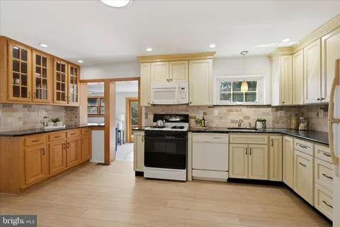 a kitchen with stainless steel appliances granite countertop a stove sink and cabinets