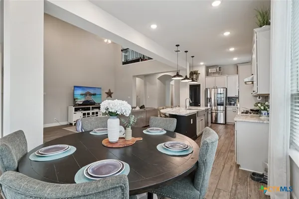 a kitchen with stainless steel appliances kitchen island granite countertop a dining table and chairs