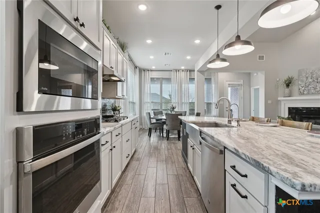 a kitchen with stainless steel appliances granite countertop a stove and cabinets