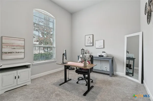 a view of a workspace with furniture and a window