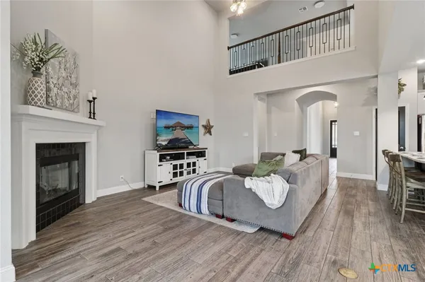 a living room with furniture a fireplace and a wooden floor