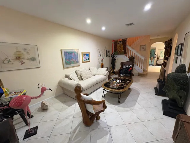 a living room with furniture and a painting on the wall