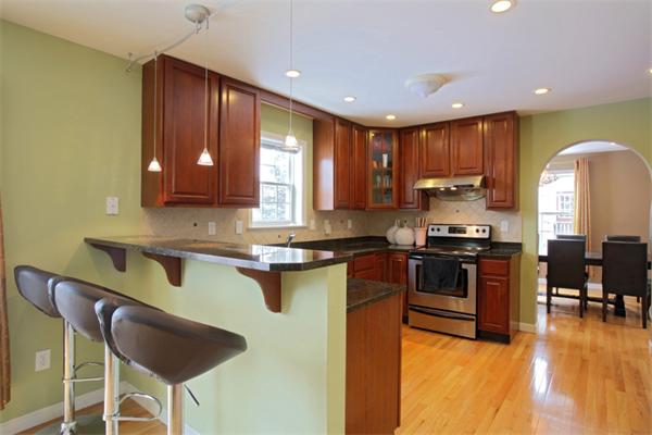 a kitchen with stainless steel appliances granite countertop a stove a sink a microwave a refrigerator and cabinets