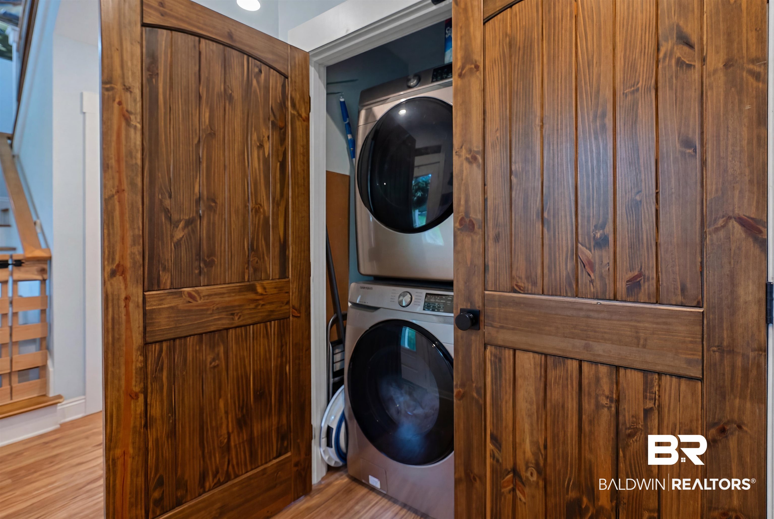 7266 Franklin Road Foley, AL 36535 - Photo 48 of 64 Integrated laundry closet featuring a stackable washer and dryer, concealed by paneled wood doors with black hardware