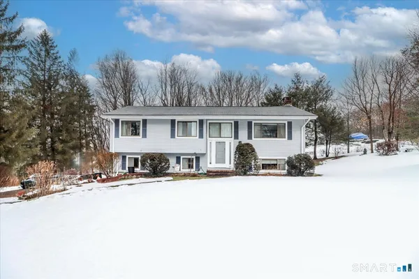 a view of a white house with a yard covered in snow