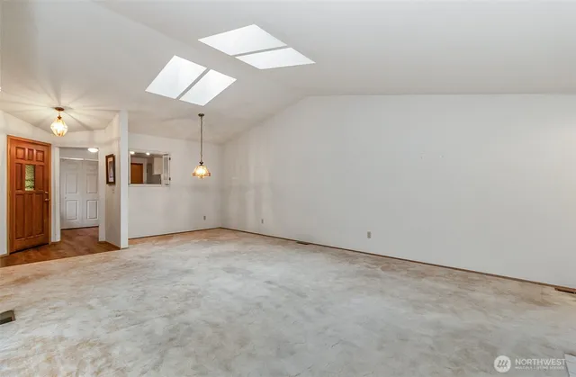 an empty room with entrance and windows