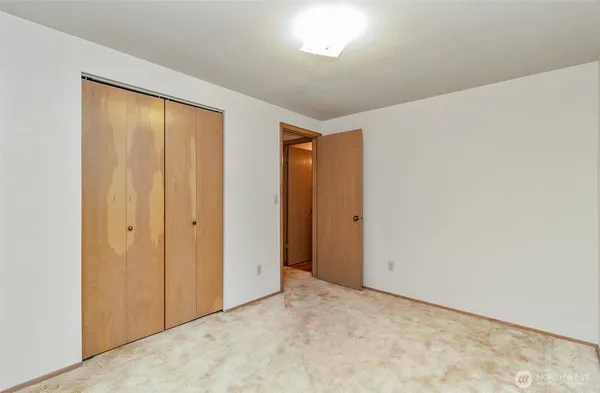 an empty room with a ceiling fan and a window