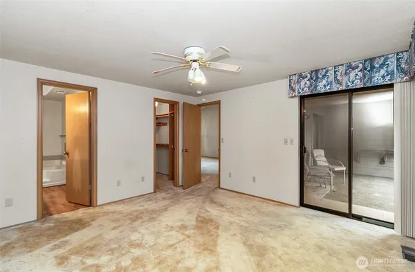 en empty room with ceiling fan and window