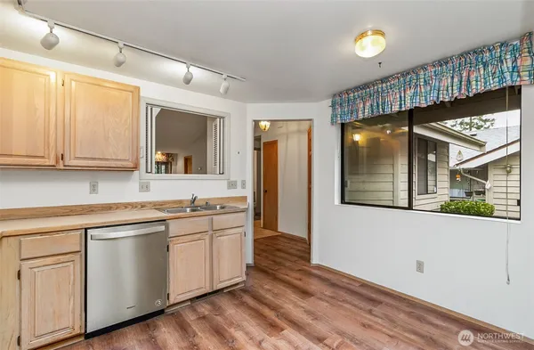 a kitchen with a sink cabinets stainless steel appliances and a window